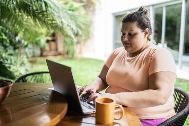 portrait of a mid adult woman working on the laptop at home