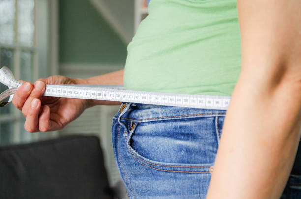 woman measuring her waist