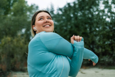 young chubby woman stretching by the river